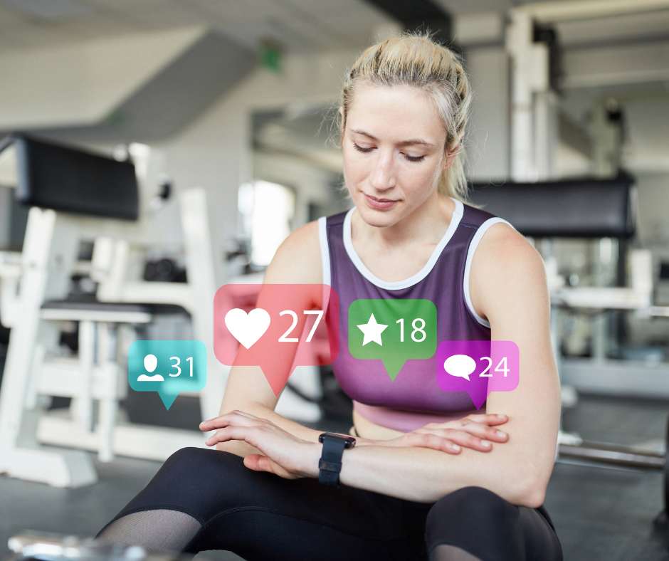 Eine junge Frau in Sportkleidung sitzt in einem modernen Fitnessstudio und schaut auf ihre Smartwatch. Vor ihr erscheinen bunte Social Media Icons mit Zahlen, die Interaktionen wie Likes, Kommentare und neue Follower darstellen. Die Frau wirkt konzentriert und zufrieden. Im Hintergrund sind verschiedene Fitnessgeräte zu sehen. Das Bild verdeutlicht die Bedeutung von Social Media für Fitnessstudios, indem es die Verbindung zwischen Fitnessaktivitäten und digitalen Interaktionen hervorhebt.